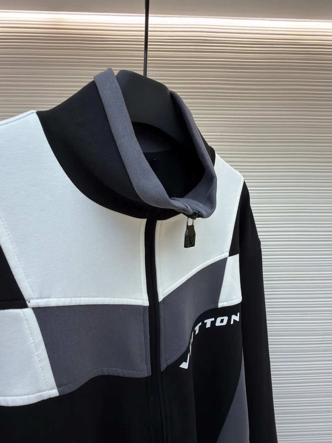 LOUIS VUITTON Spliced jogging sweatshirt long-sleeved sweatshirt ●Original version: Purchased and developed by 13126 ●Item number: 1682019-B70 ●Fabric: 100% cotton ●Technology: Made by positioning cutting machine ●Color: black, gray and white ●Version: fitted version ●Weight: about 1015 grams ●Size: S-M-L-XL ●Description: This Louis Vuitton color-blocked jacket is made of high-elastic composite knitted fabric (polyester fiber + spandex blend), which has been treated with matte brushing, giving it both stiffness and skin-friendly feel. The body of the garment adopts geometric color-blocking cutting technology: black, gray, and white pieces are spliced ​​diagonally in a V-shape, and the edges are processed by "laser seamless fit + same-color overlocking" to ensure smooth seams without any irritation. The "VUITTON" logo on the chest uses a three-dimensional silicone imprinting process. It is first laid with a low-temperature setting glue layer and then covered with a matte coating to take into account the three-dimensionality and washability of the logo. The neckline is a stand-up collar design with built-in elastic lining reinforcement; the zipper is made of brand-customized metal, and the chain teeth are the same color as the fabric; the cuffs and hem are equipped with high-elastic ribbing, and the overall shape is ergonomically optimized to suit daily casual scenes. The overall wiring is straight and delicate, the fabric is comfortable and soft, and the color is consistent without color difference. It can be matched with the same style to create a fashionable look and control various occasions. Customized accessories, complete with three standards, same style for men and women!